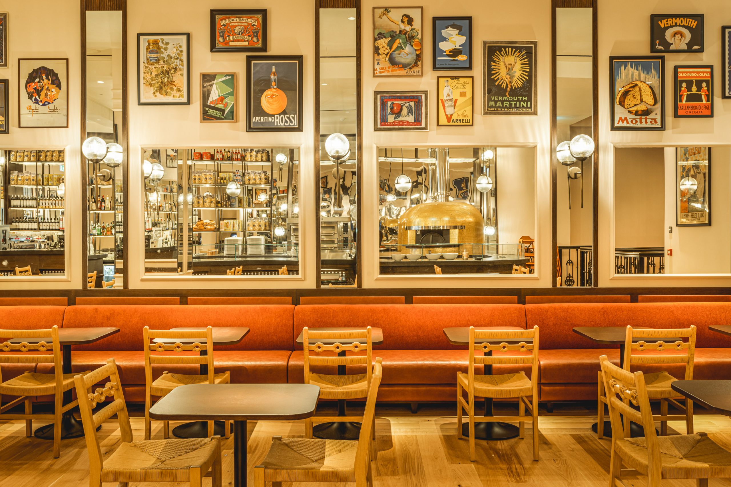 Interior of Luci in Covent Garden London with mirrors, framed pictures, and seating area.