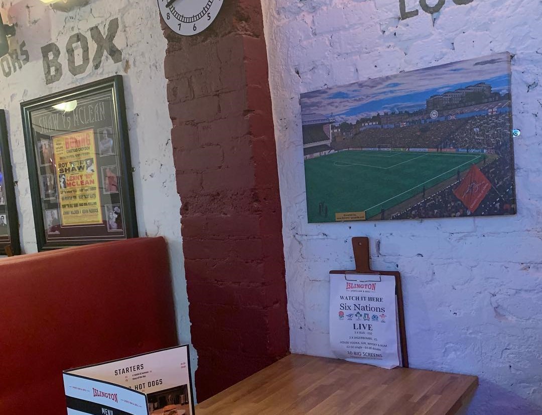 table and decorated wall of the islington sports bar & grill